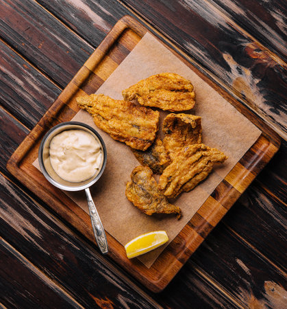 fried cod fillet pieces on wooden trayの写真素材
