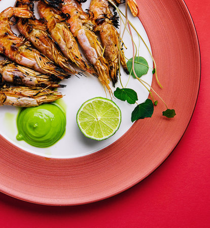 grilled tiger prawns or shrimps on red plateの写真素材