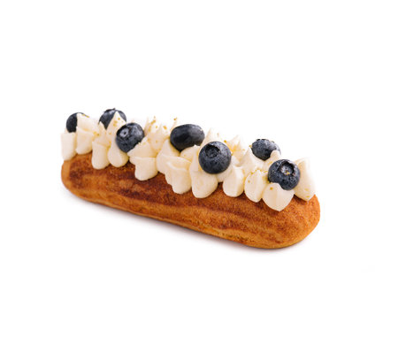 Eclair with buttercream and blueberries isolated