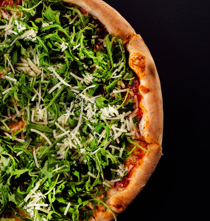 Pizza with arugula and parmesan on blackの写真素材