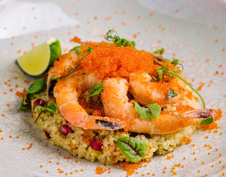 Couscous with vegetables and shrimp under red caviarの写真素材
