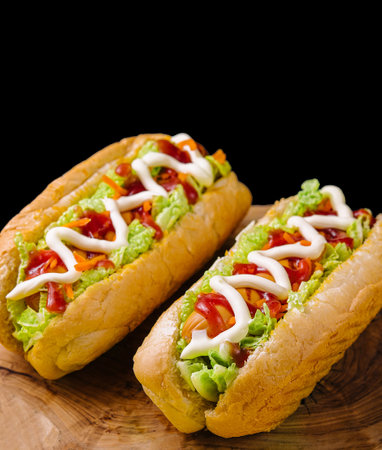 Two delicious hotdogs on wooden board