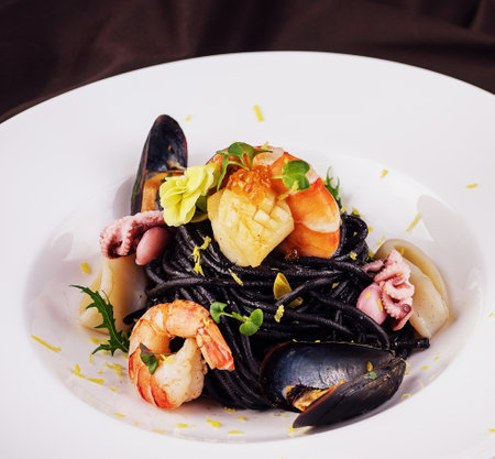 Black spaghetti with seafood on white plateの写真素材