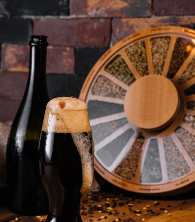 Glass of dark beer and bottle on woodenの写真素材