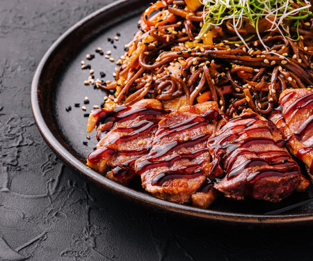 Soba beef and vegetables, Buckwheat noodles on a dark stone backgroundの写真素材