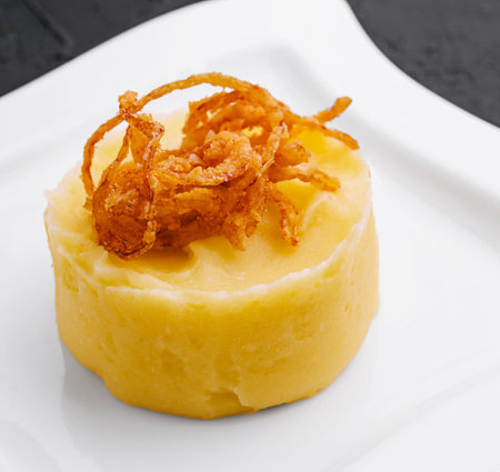 mashed potatoes with onion chips on plateの写真素材