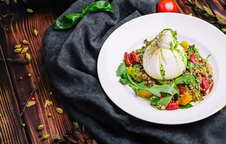 Delicious summer salad with burrata cheese and grilled peaches, arugula and microgreens