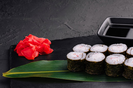 Crab stick maki sushi on black trayの写真素材