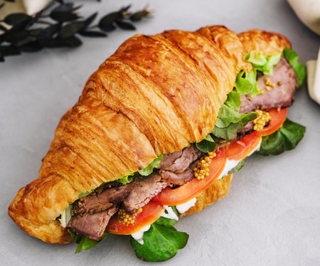 croissant with boiled pork and tomatoesの写真素材