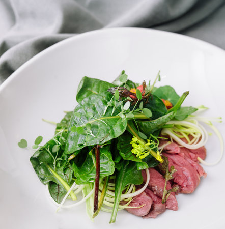 warm meat salad on white plateの写真素材