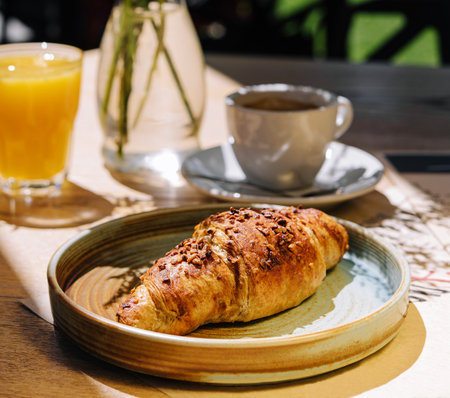 Cup of fresh hot coffee, orange juice and traditional french croissant on table of parisian outdoor cafe in parisの写真素材