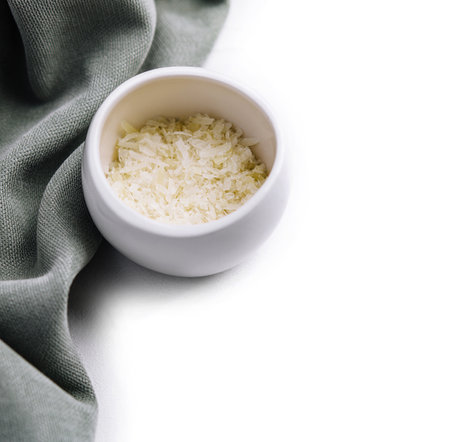 Grated aged italian parmesan cheese in white bowlの写真素材