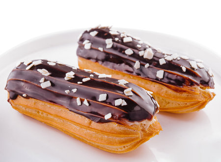 Two eclairs with chocolate glaze in white plate