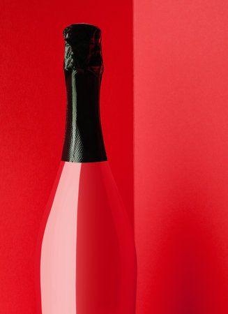 Red bottle of champagne on yellow backgroundの写真素材