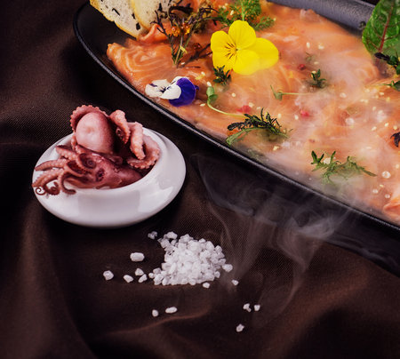 Smoked salmon carpaccio and octopus with white smoke of liquid nitrogenの写真素材