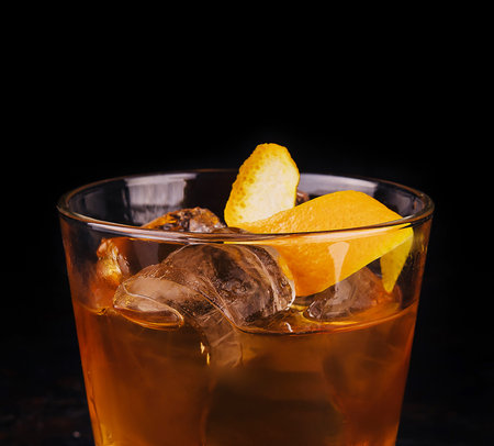 Old-fashioned cocktail with ice and orange peelの写真素材