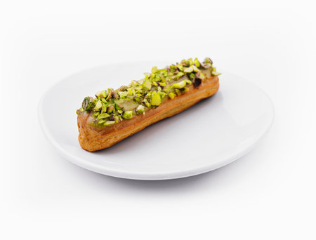 Delicious eclair with pistachio and cream