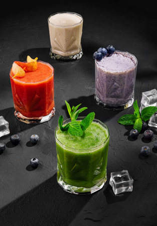 Freshly blended fruit smoothies of various colors and tastes in glassの写真素材