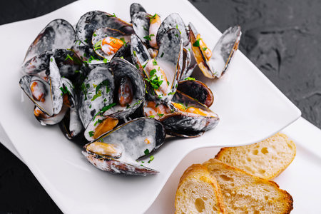 Plate of tasty mussels with parsley and toasted breadの写真素材