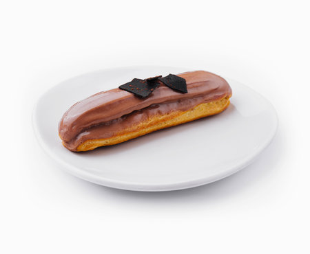 Eclair topped with chocolate on white plate