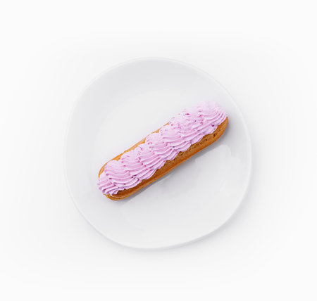 Eclair dessert with pink whipped cream on plateの写真素材
