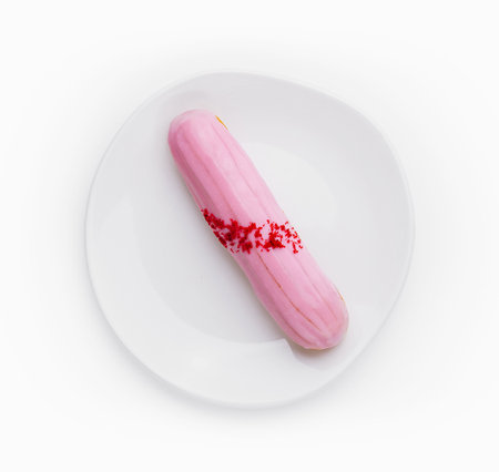 Eclair dessert with pink icing on plate