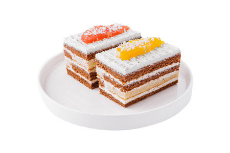 two slices of multilayer cocoa sponge cake with coconut flakesの写真素材