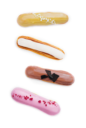 different types of eclairs with different glazes isolated on white backgroundの写真素材