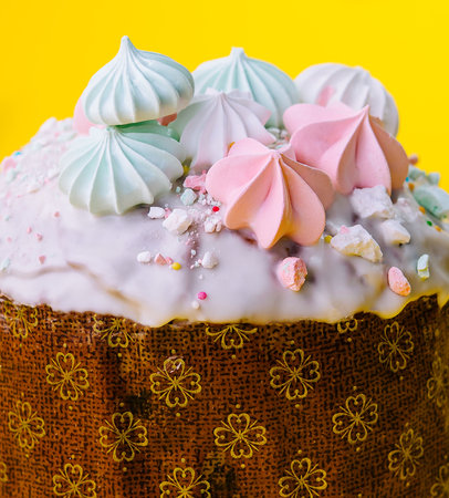 Traditional Easter cakes with meringue on yellow background