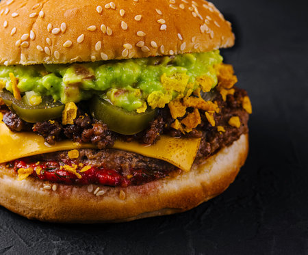 veggie burger with guacamole and pickles on toasted bunの写真素材