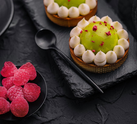 Slice of matcha cake with vanilla and raspberriesの写真素材