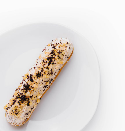 Eclair with cream and chocolate on plate