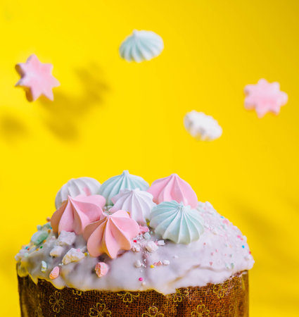 Traditional Easter cakes with meringue on yellow background