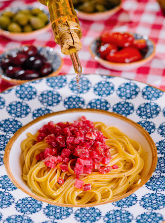 chef pouring olive oil on spaghetti with tunaの写真素材
