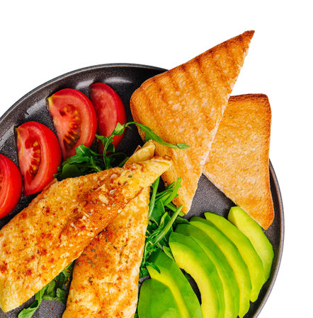 Omelette with avocado, tomatoes and arugula on black ceramic plateの写真素材