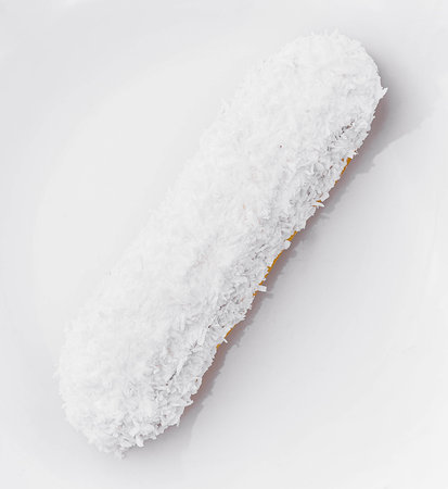 eclair in white glaze and coconut flakesの写真素材