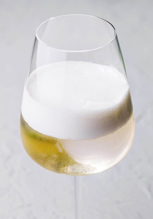 white cocktail with foam in a wine glassの写真素材