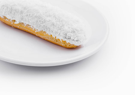 eclair in white glaze and coconut flakes