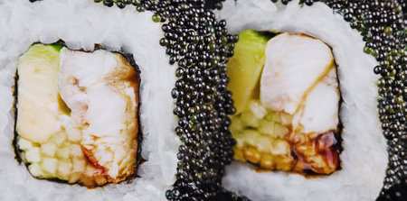 Sushi rolls with salmon, eel, cheese, avocado and black tobiko caviarの写真素材