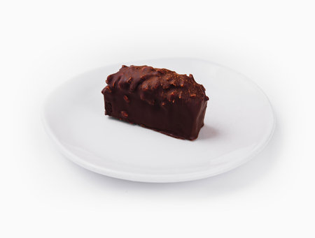 Single chocolate bar with nuts on a clean white plate isolated on a white backgroundの写真素材