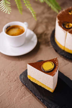 Elegant serving of passionfruit cheesecake paired with an espresso on a textured tabletopの写真素材