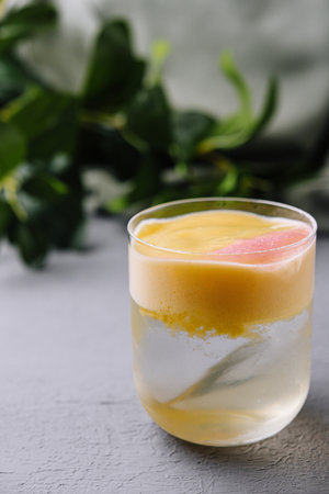 Chilled tropical smoothie with a fresh grapefruit garnish, served in a clear glassの写真素材