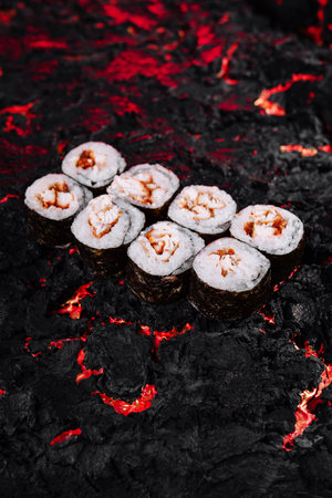 Elegant sushi rolls artfully placed on a dramatic, fiery, lava-inspired backgroundの写真素材