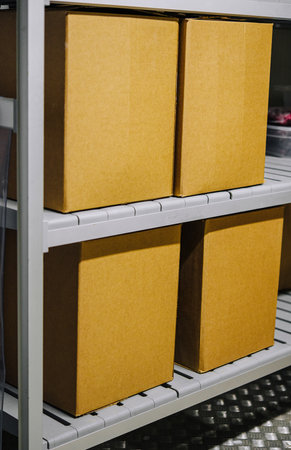 Close-up of neatly stacked cardboard boxes on shelves in a storage room