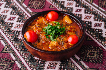 Savory homemade stew with vegetables and herbs served in a rustic clay potの写真素材