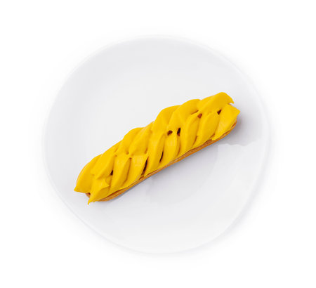 Vibrant mango eclair presented on a pure white circular plate, isolated on white background