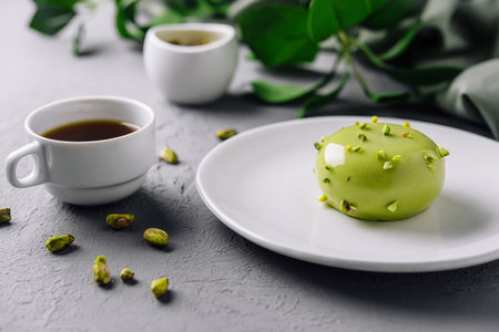 Stylish setup of a pistachio dessert and coffee cup on a modern grey backgroundの写真素材