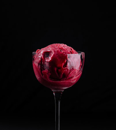 Close-up of a tempting strawberry sorbet served in a delicate glass against a dark backdropの写真素材