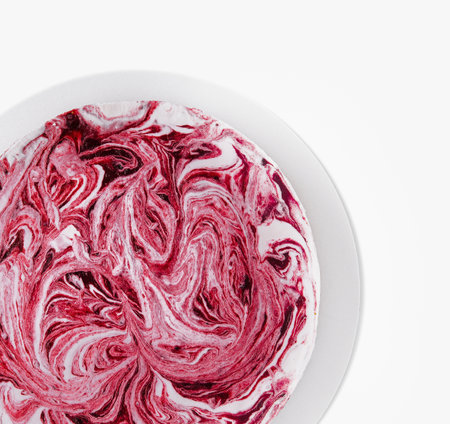 Top view of a plate with a swirl of mixed berry cake in yogurtの写真素材