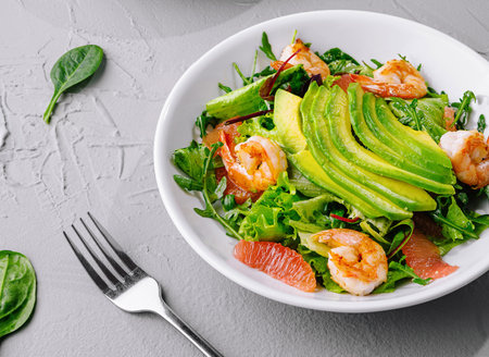 bowl of vibrant shrimp avocado salad, perfect for healthy eating, on a gray textured backgroundの写真素材